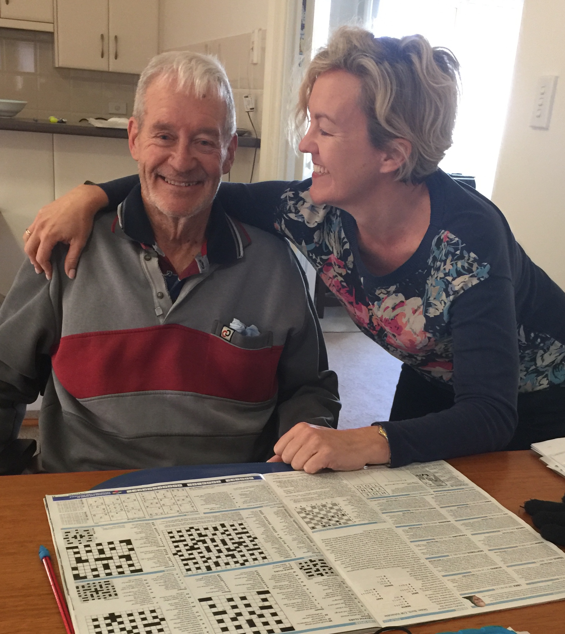 Smiling Older Father and Daughter doing Crossword Sudoku together