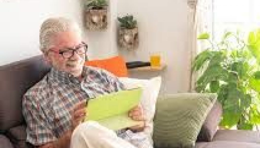 Senior gentlemen happily reading the paper in his own home